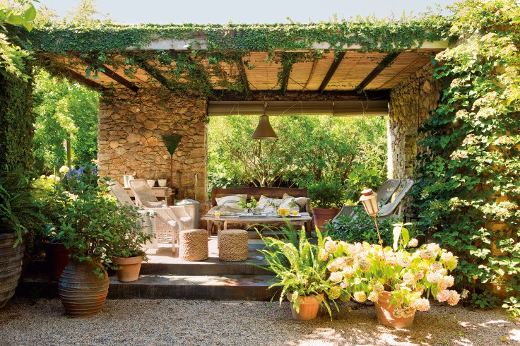 pergola-con-techo-de-canizo-y-paredes-de-piedra-en-jardin_a783a6e7